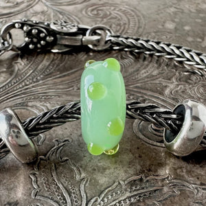 Rare, Trollbeads "Applegreen Bud" glass bead shown on a Trollbeads silver bracelet with two spacers and a lock.