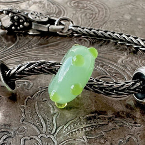 Rare, Trollbeads "Applegreen Bud" glass bead shown on a Trollbeads silver bracelet with two spacers and a lock.