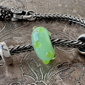 Rare, Trollbeads "Applegreen Bud" glass bead shown on a Trollbeads silver bracelet with two spacers and a lock.