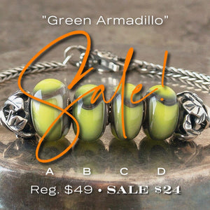 Four versions of glass Green Armadillo Trollbead, with lime and charcoal scale-like design, on Trollbeads silver bracelet.