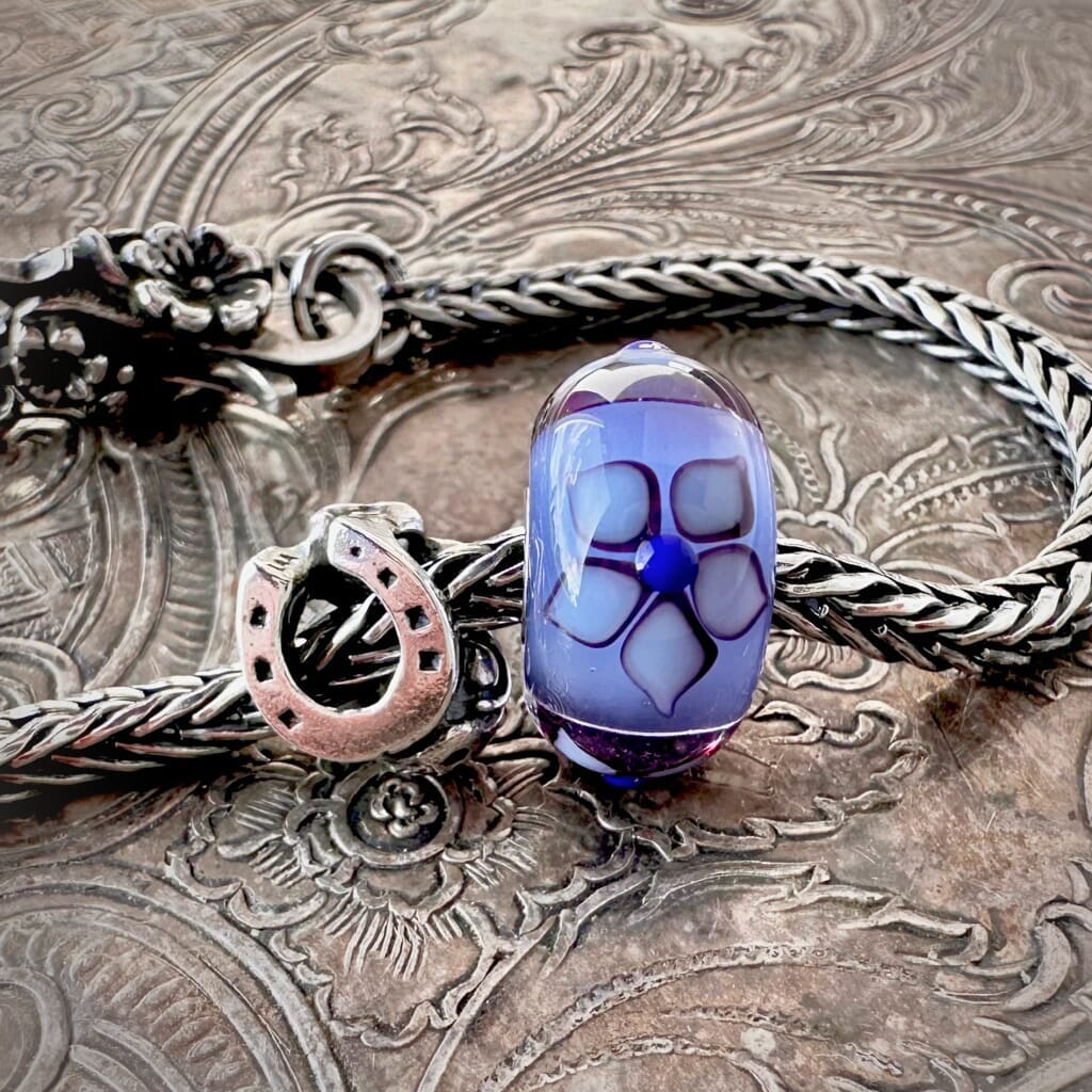 Suzie Q Studio's beautiful limited edition Trollbeads "GOOD LUCK" Starter Bracelet includes: a sterling silver "messenger of good luck" bead, a gorgeous glass bead with the flower of Love, and a ladybug lock as well as a Trollbeads classic foxtail-chain bracelet.