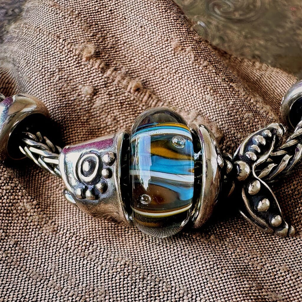 Trollbeads, JEWEL OF SEA, sterling silver, two-part pendant of a fish, shown on a Trollbeads bracelet with a glass bead in between the two parts.