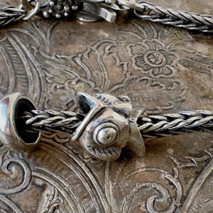 Trollbeads, NEITHER FISH NOR BIRD, BIG is a whimsical, fish-bird design, sterling silver bead, shown on a silver Trollbeads bracelet.