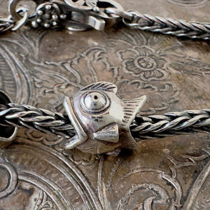 Trollbeads, NEITHER FISH NOR BIRD, BIG is a whimsical, fish-bird design, sterling silver bead, shown on a silver Trollbeads bracelet.