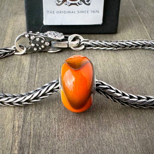 Available at Suzie Q Studio dot com, Trollbeads retired ORANGE ARMADILLO #2 glass bead, shown on a silver chain with a clasp.