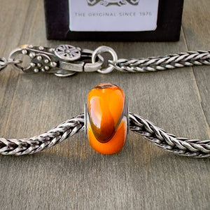 Available at Suzie Q Studio dot com, Trollbeads retired ORANGE ARMADILLO #3, glass bead, shown on a silver chain with a clasp.