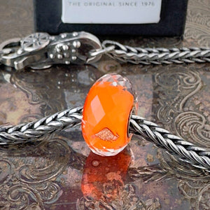 Available at Suzie Q Studio dot com, Trollbeads retired, limited edition, ROYAL ORANGE faceted, glass bead, in vibrant orange, on a silver chain with a clasp.