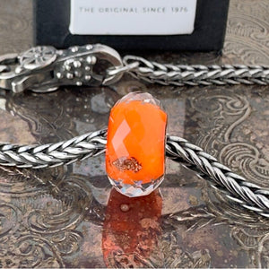 Available at Suzie Q Studio dot com, Trollbeads retired, limited edition, ROYAL ORANGE faceted, glass bead, in vibrant orange, on a silver chain with a clasp.