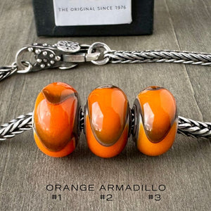 Available at Suzie Q Studio dot com, Trollbeads retired ORANGE ARMADILLO glass bead. Three versions shown on a silver chain with a clasp.