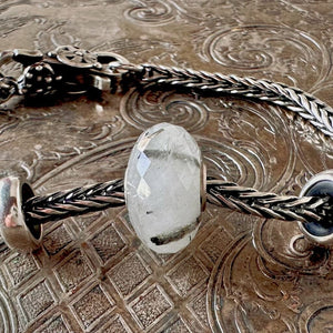 Trollbeads TOURMALINATED QUARTZ, semi-precious stone bead, which features unique inclusions and is shown on a silver Trollbeads bracelet.